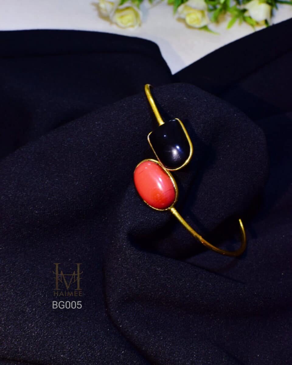 Modern stone bracelet with contrasting black and red gemstones. Gold plated, perfect for adding a unique and colorful touch to your look. Shop now!