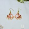 Hand painted peacock drop earrings featuring light pink Meenakari designs and pink bead trim. Gold-plated, artisan crafted. Discover them today!