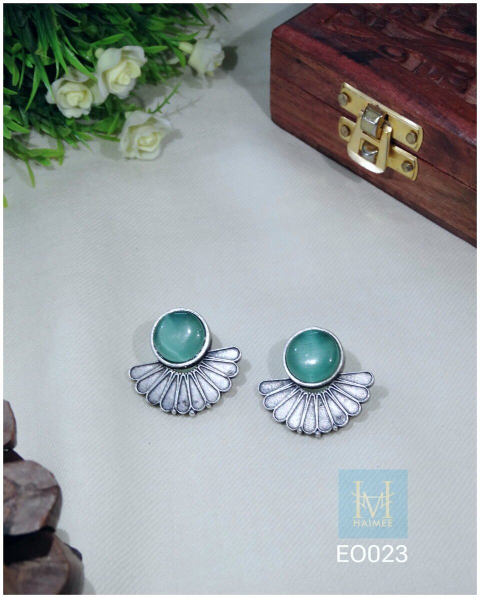 Fan-shaped oxidized silver studs with green stone centerpiece, showcasing modern Indian tribal jewellery style.