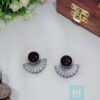 Fan-shaped oxidized silver stud with stone on display, showcasing modern Indian tribal jewellery design.