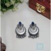 Silver crescent moon-shaped tribal earrings with blue stone detailing, showcased on a product page for tribal jewellery online India.