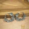 Classy floral design silver design earrings made from brass placed on a wooden surface