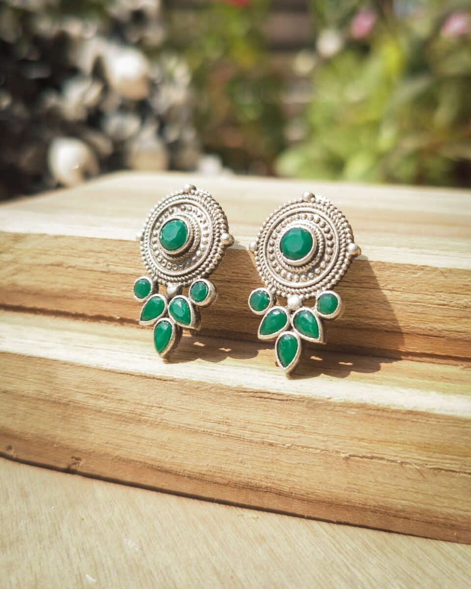 Simple yet stylish oxydised silver studs with petal-shaped green Mona Lisa stones. Ideal for everyday wear for girls. Discover these unique earrings