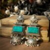 Handcrafted brass jhumka earrings with a vibrant green Monalisa stone and an silver oxydised finish. Embrace traditional Indian style with these statement earrings!
