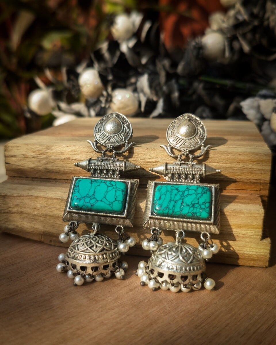 Handcrafted brass jhumka earrings with a vibrant green Monalisa stone and an silver oxydised finish. Embrace traditional Indian style with these statement earrings!