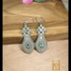 Unique design silver oxydized brass earrings with light blue stone placed on wooden surface