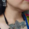 Silver oxydised brass choker necklace with peacock motifs, blue accents, and matching dangler earrings